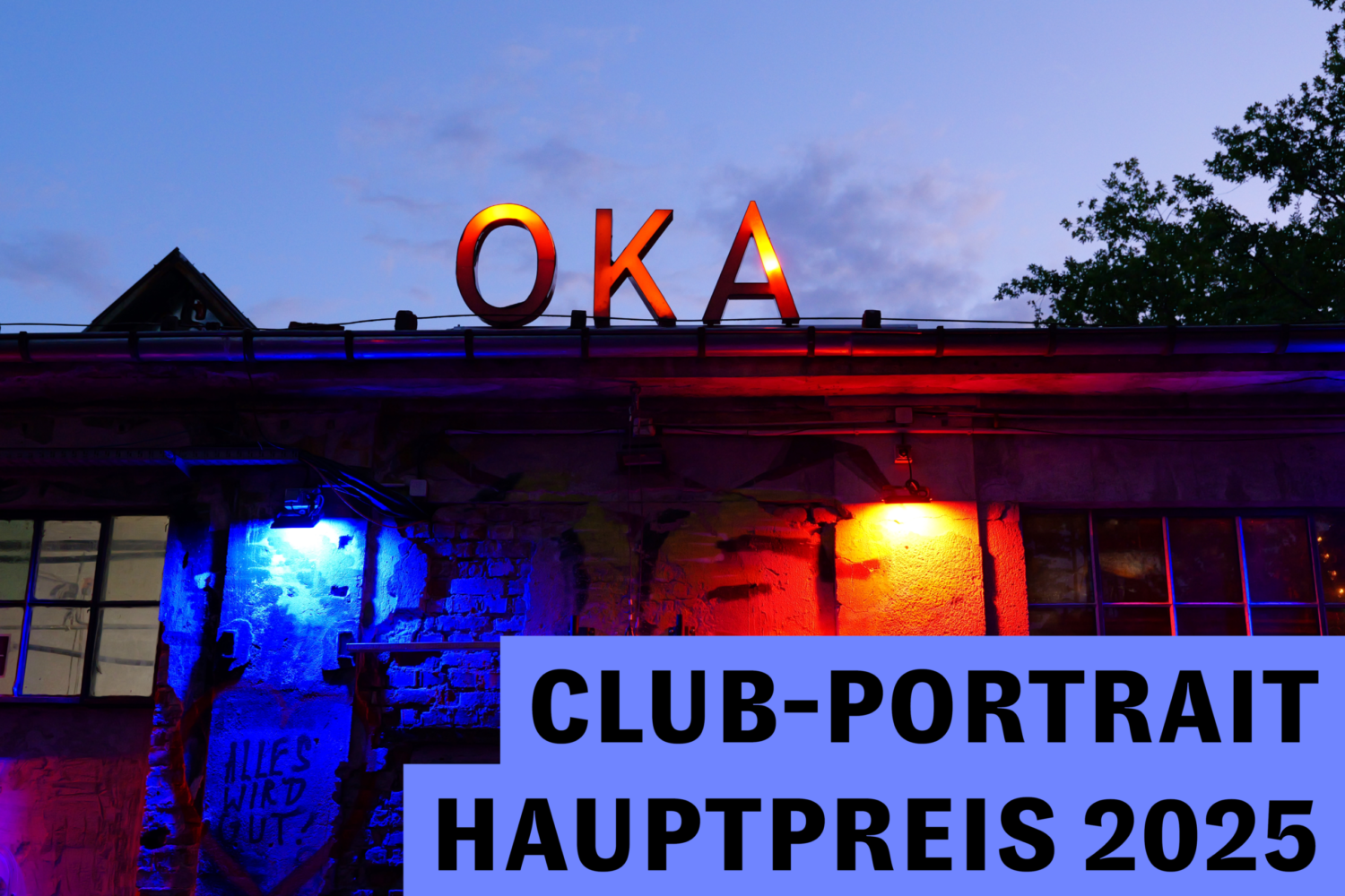 Industriegebäude mit dem leuchtenden Schriftzug „OKA“, beleuchtet in Blau- und Rottönen bei Abenddämmerung.