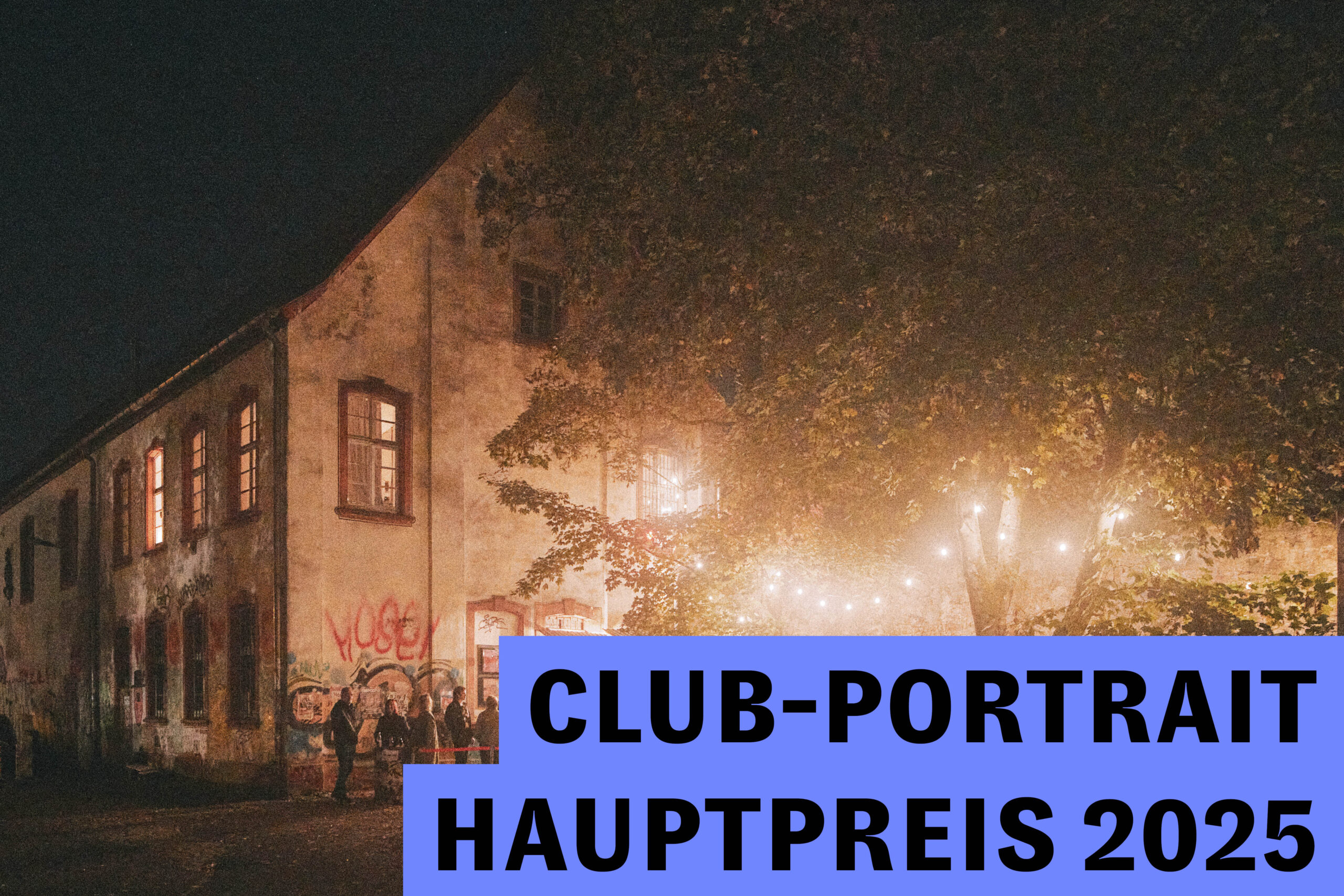 Historisches Kulturgebäude bei Nacht mit beleuchtetem Innenhof und Besucher:innen vor dem Eingang.